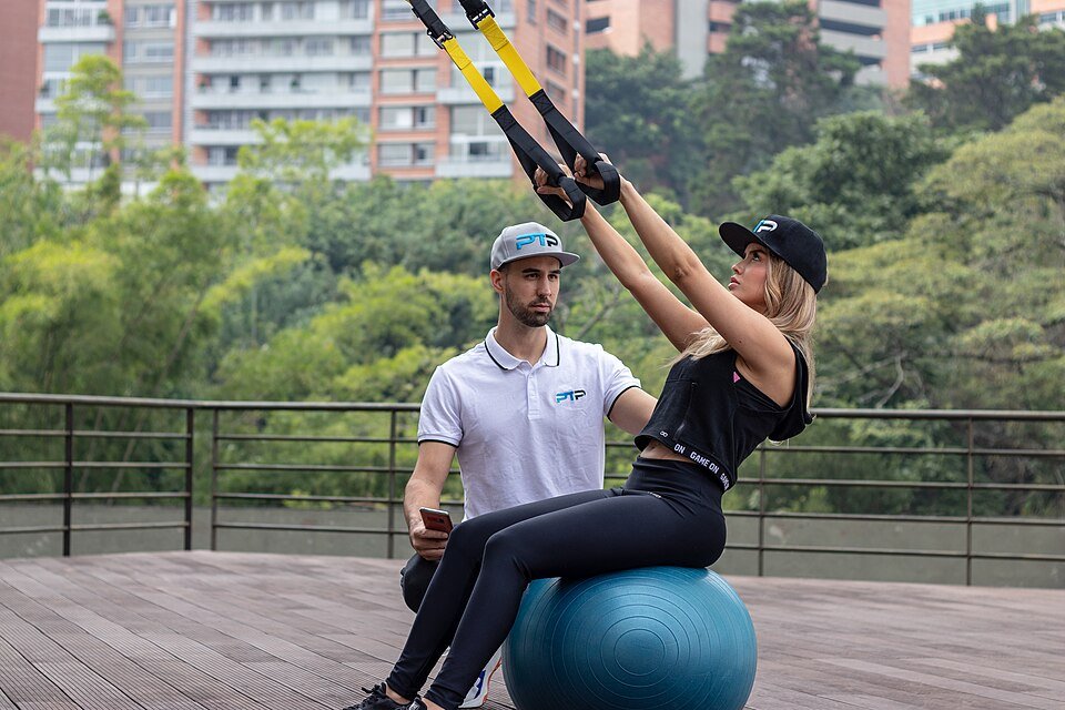 Person performing a TRX suspension row, a similar rowing/pulling motion to the barbell row