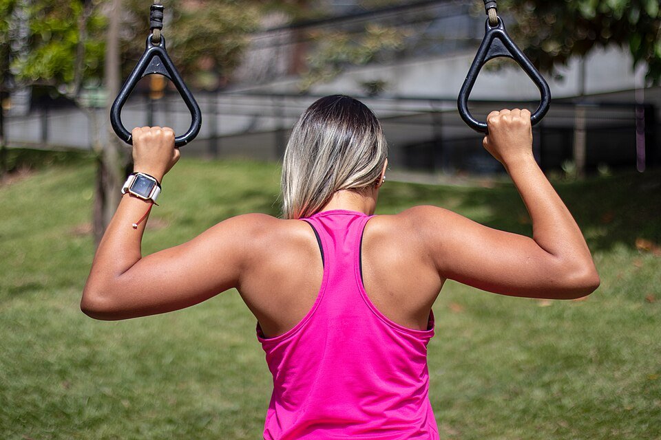 Person performing a pull-up on a bar with an overhand grip